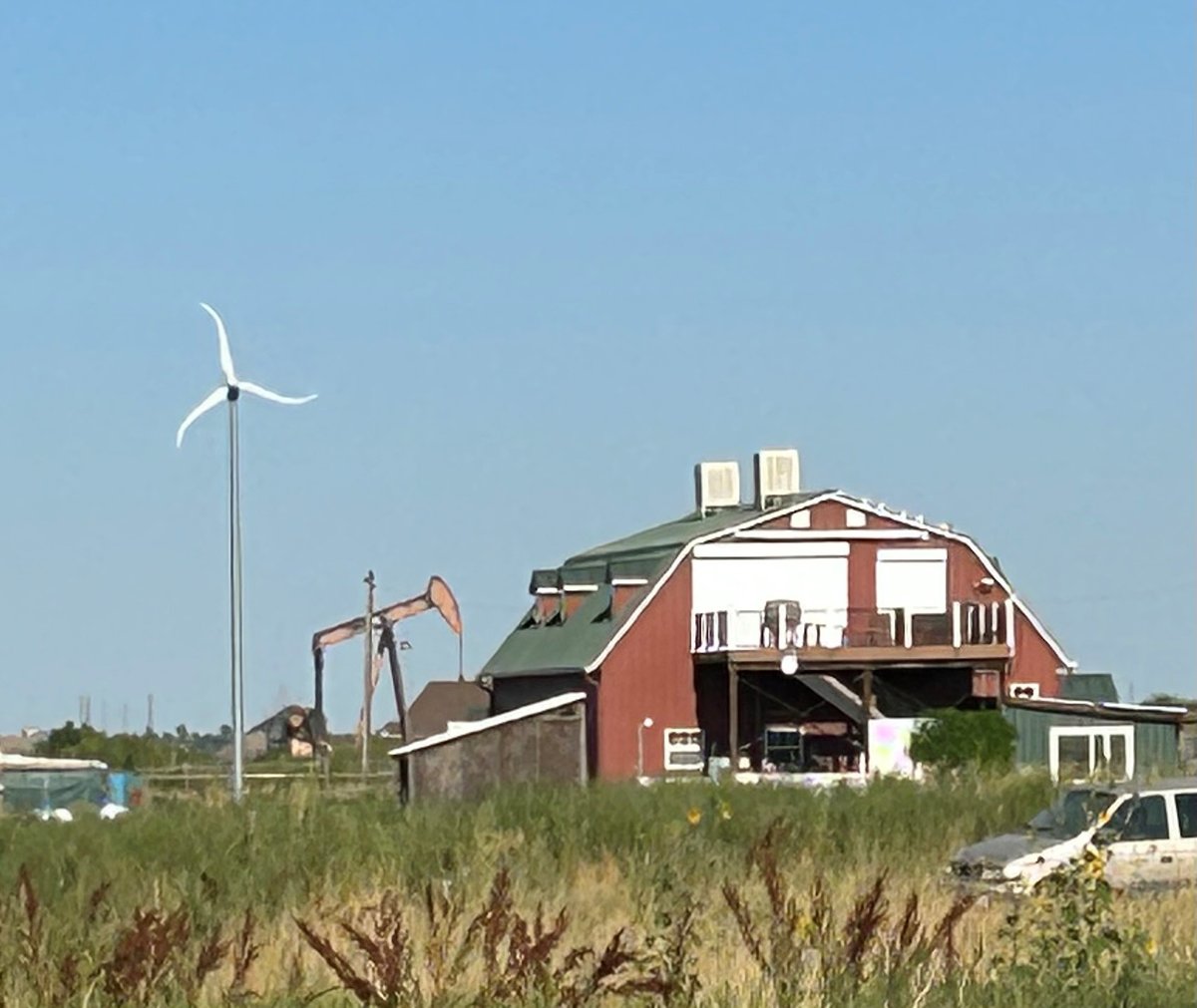 An oil rig and a wind turbine running side by side at a farm outside of Boulder in Colorado